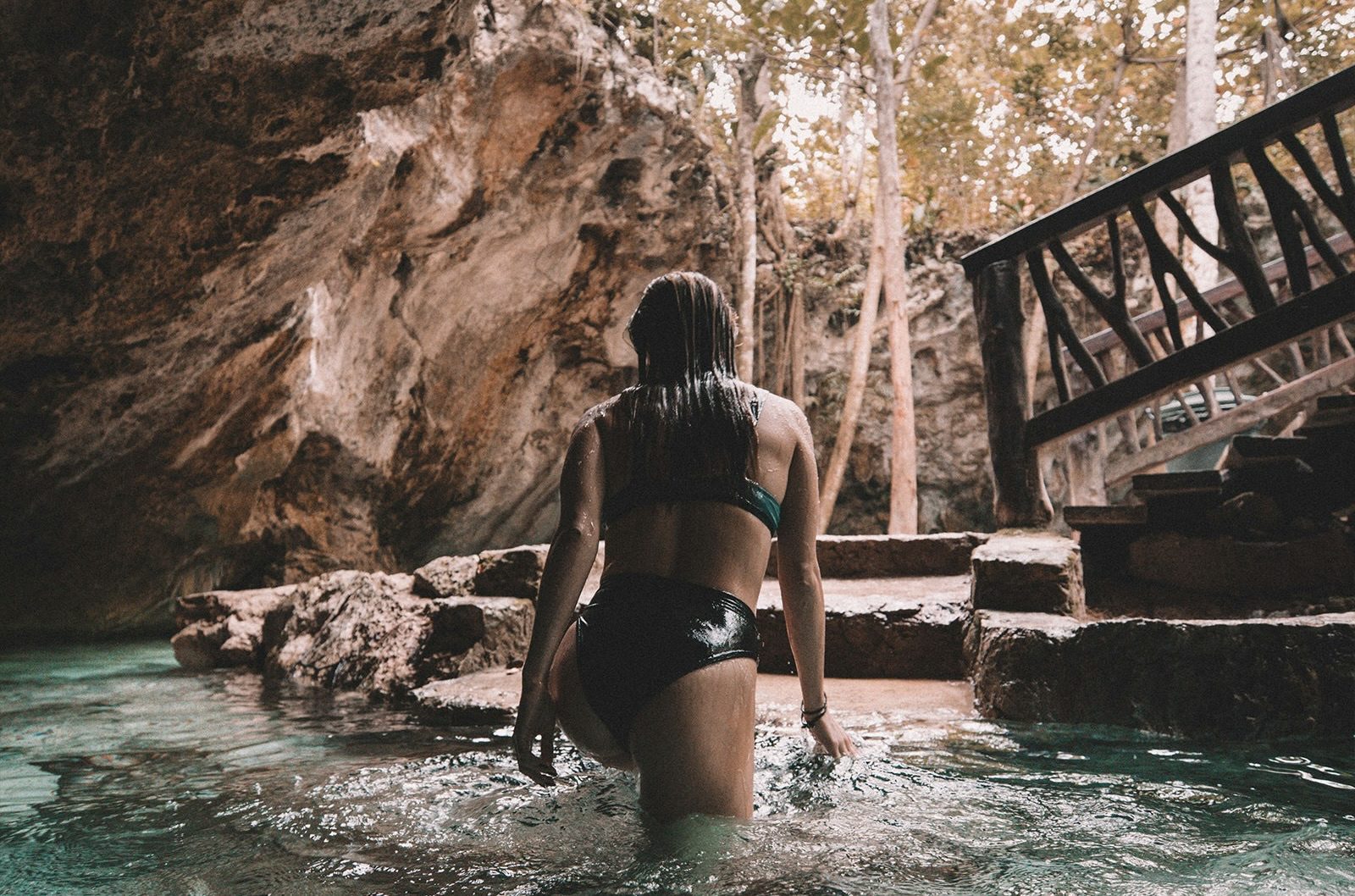 Een vrouw in een cenote in Tulum, Mexico.