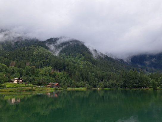 Uitzicht over een meer met mistige bergen