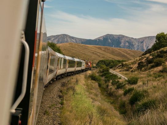 Een trein rijdend door een bergachtig gebied.