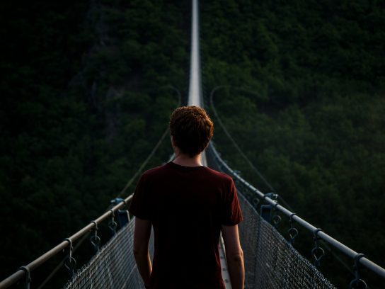 Een man staand op hangbrug Geierlay in Duitsland.