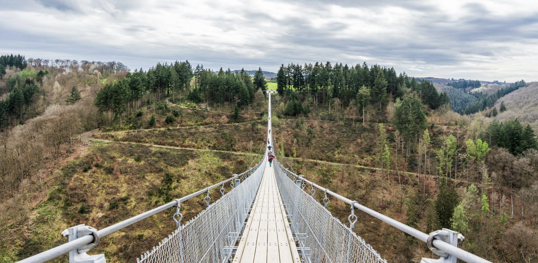 Mensen wandelend over hangbrug Geierlay in Duitsland.