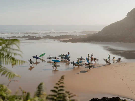 Een groep surfers op het strand in Portugal.