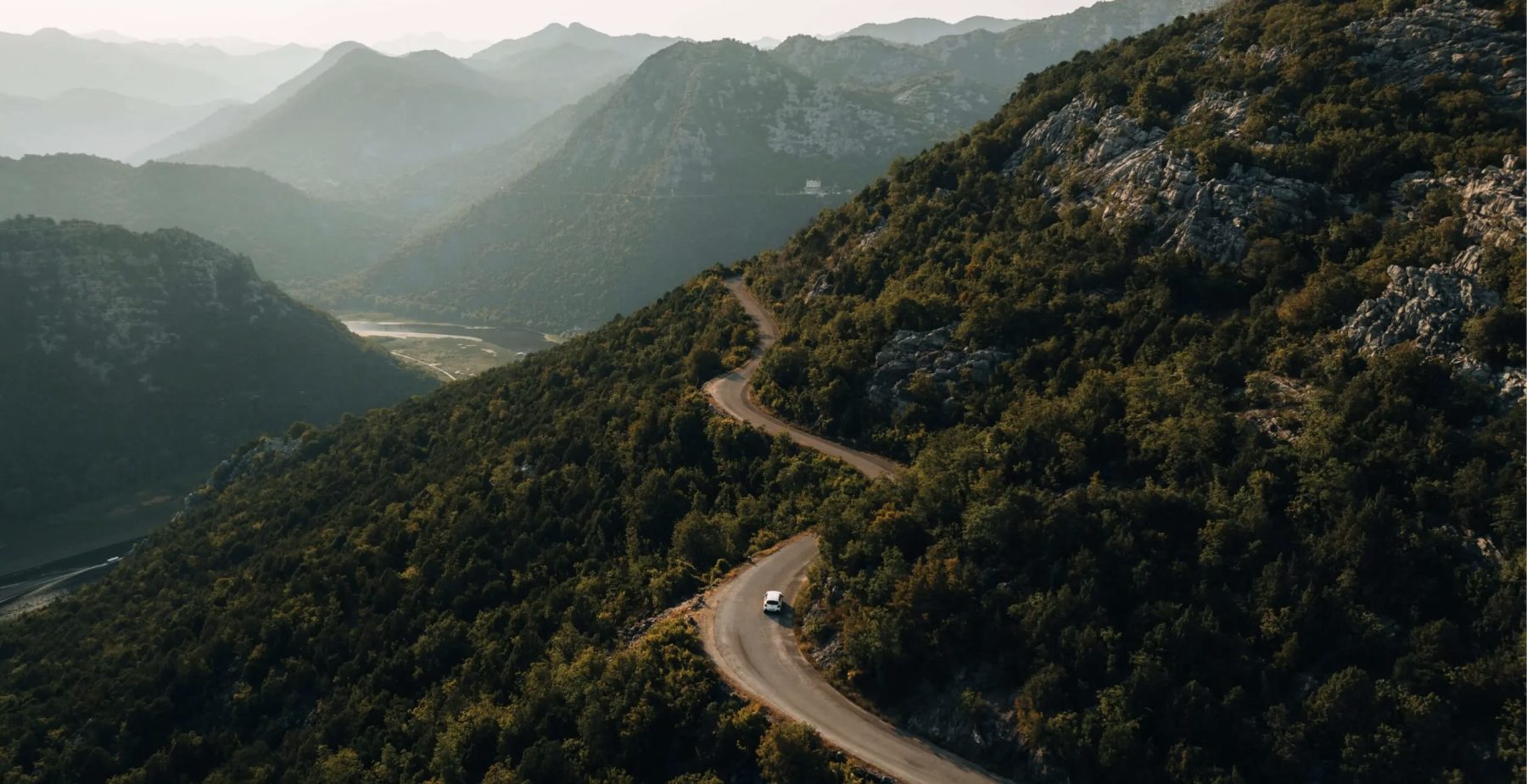 Een auto rijdend over een bergweg in Albanië.